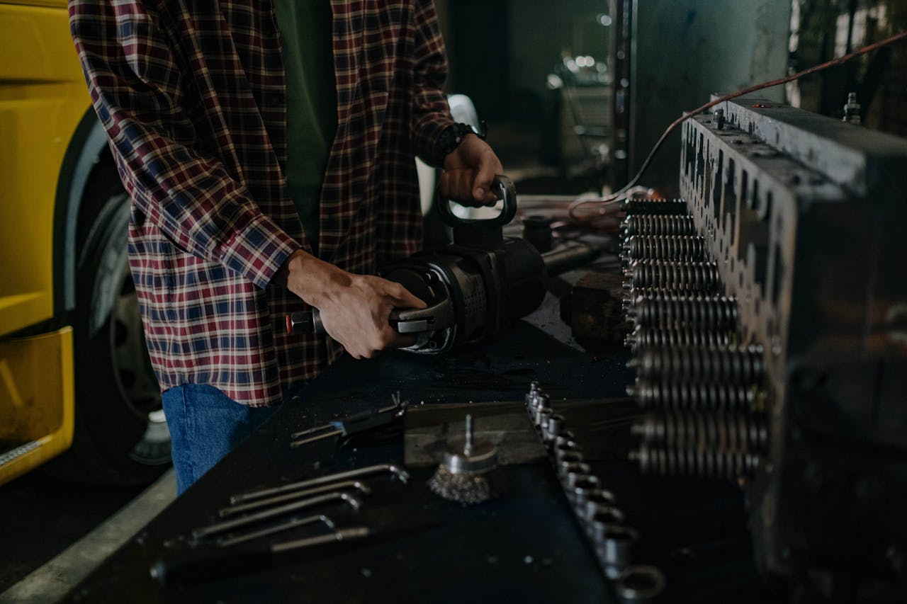 Mechanic using tools in an auto repair workshop for vehicle maintenance.